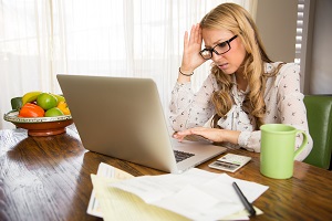 frustrated woman doing taxes at computer